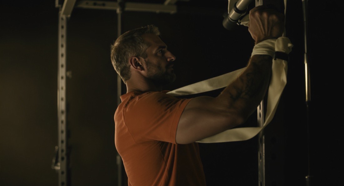 A man in his fifties performing a banded external rotation drill for the rotator cuff